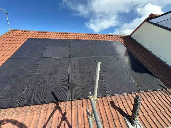 A full roof of black panels, seen from the scaffold