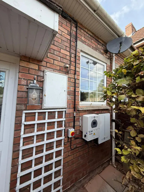 Inverter and battery tucked beside a garden trellis