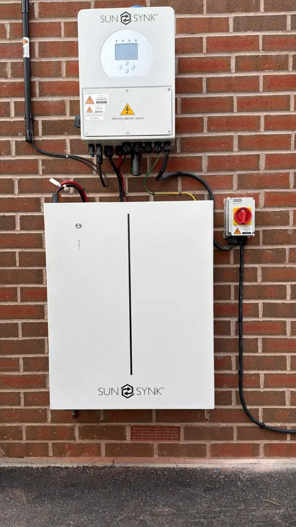 SunSynk battery with its isolator on a brick wall